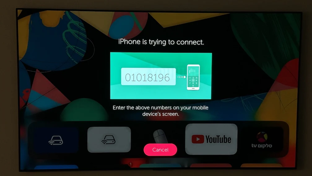 スマートフォンに入力するペアリングコードを表示しているLGのテレビ